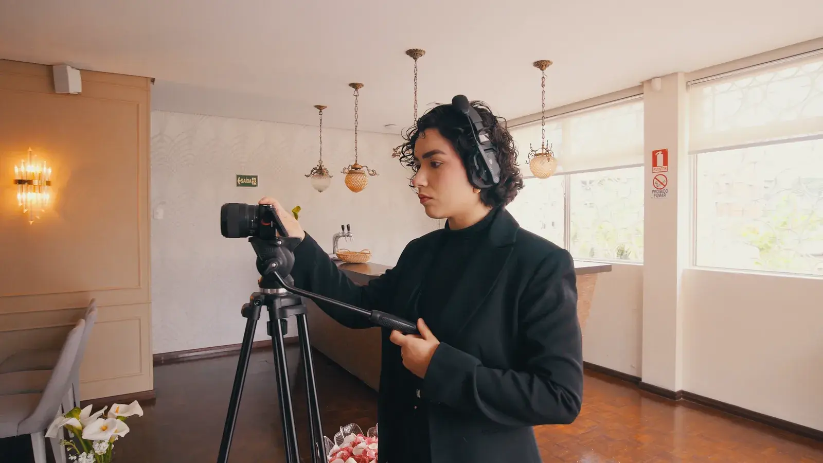 Tamires filmando um evento com a câmera no tripé